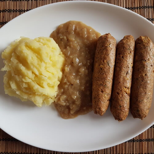 Vegan sausage with onion sauce and mashed potatoes